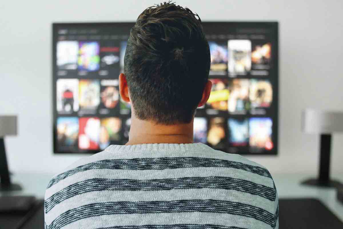 Una persona davanti alla tv che sceglie una serie TV