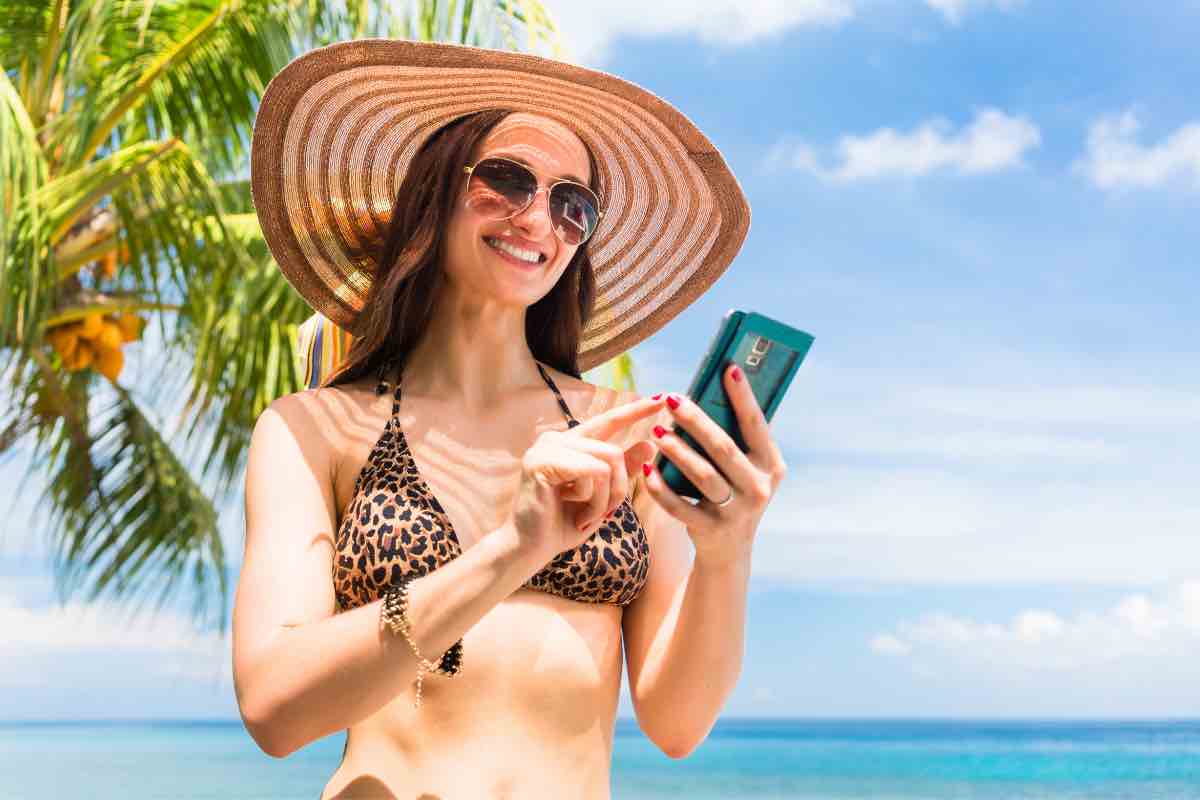 Una ragazza usa il cellulare in spiaggia