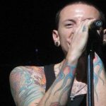 Chester Bennington con microfono sorride sul palco