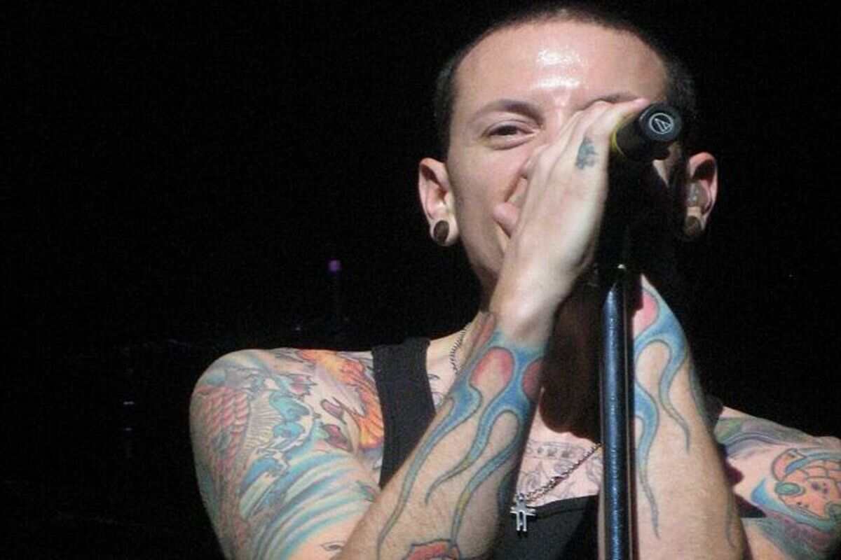 Chester Bennington con microfono sorride sul palco